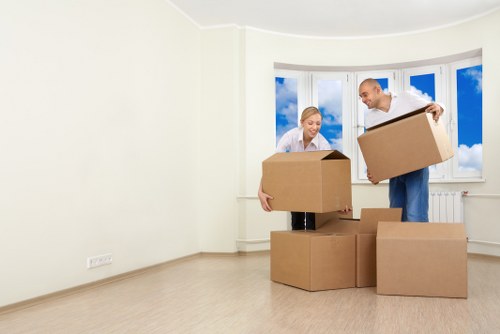 Careful lifting and moving of boxes with a trolley in a storage aisle