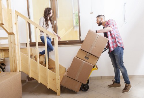 Moving team carrying items through a Belsizepark building